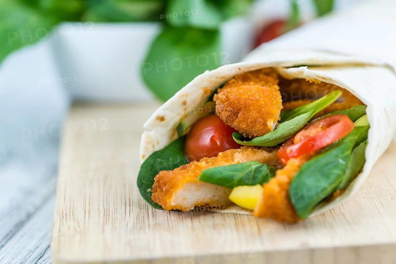 Chicken Wraps on a wooden table as detailed close-up shot (selective focus)