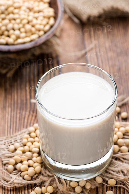 Soy Milk with some Seeds (close-up shot) on wooden background