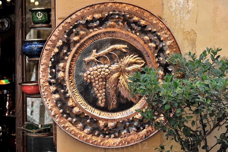 Montepulciano, Val d'Orcia, Province of Siena, Tuscany, Italy, Europe, An antique copper plate with grape relief, decorated with plants, Tuscany, Europe Italy, Europe
