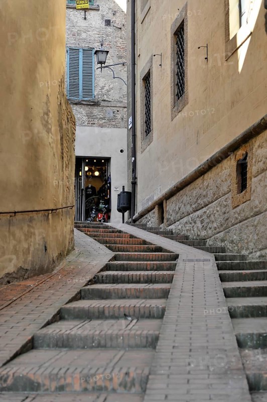Volterra, Tuscany, Italy, Europe, A narrow alley in an old town centre leads up steps to an open building with traditional shutters, Tuscany, Europe Italy, Europe