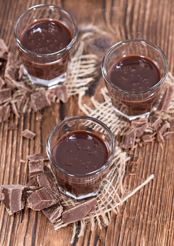 Glass with Chocolate Liqueur (close-up shot) on rustic background