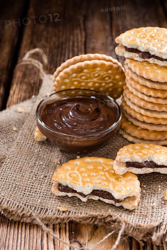 Portion of Chocolate Cream Cookies (on wooden background)