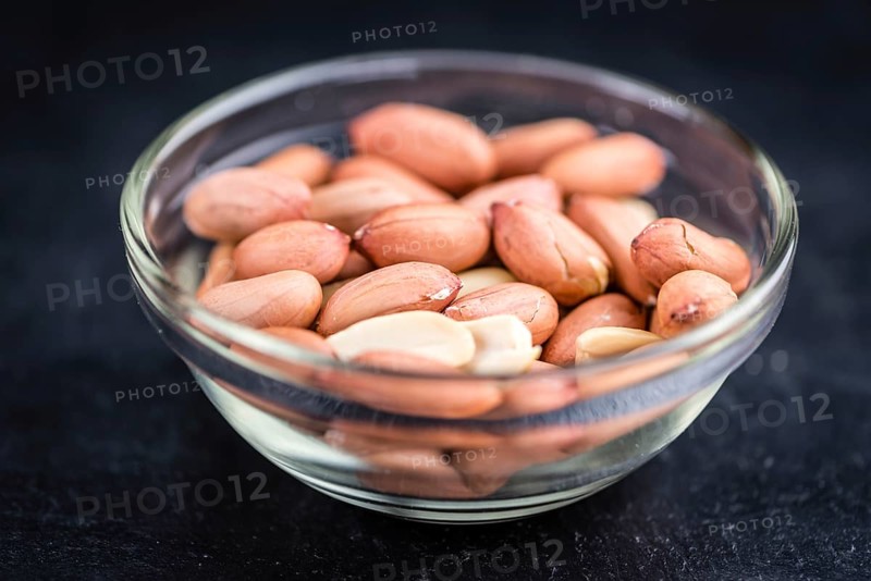 Portion of Peanut Seeds on rustic background (selective focus, close-up shot)