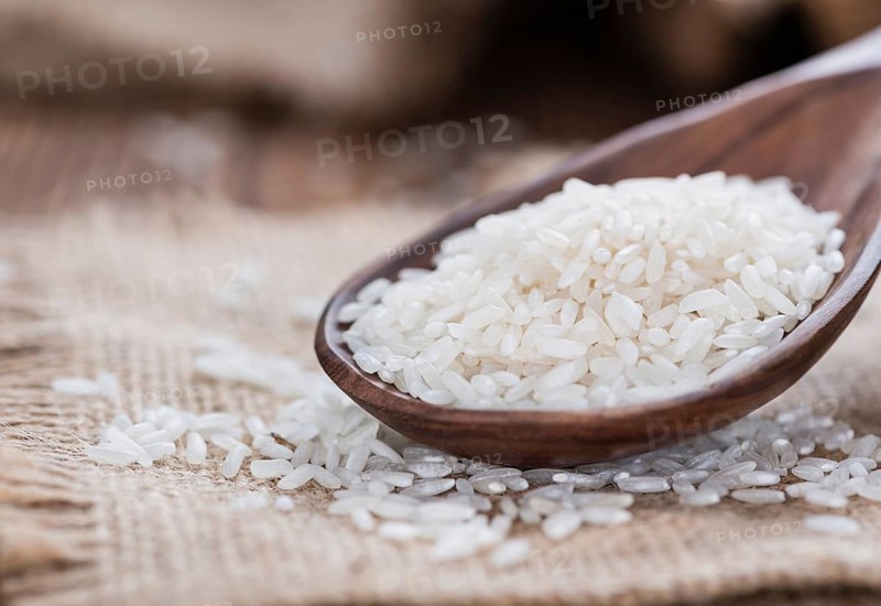 Portion of uncooked Rice on rustic wooden background