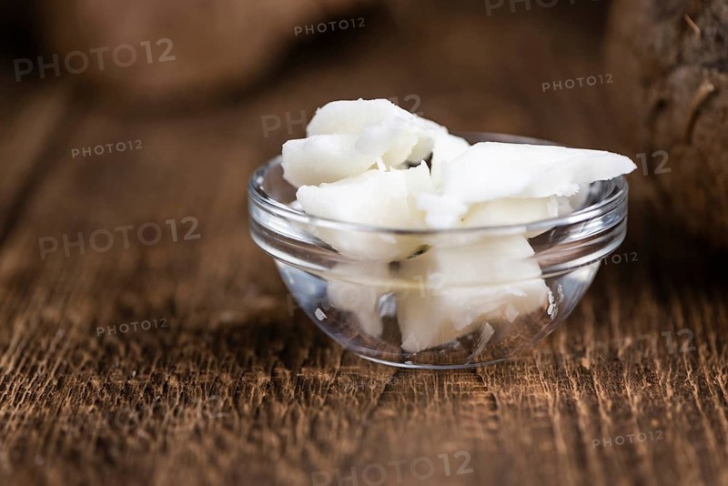 Coconut Oil (selective focus) on an old wooden table (close-up shot)