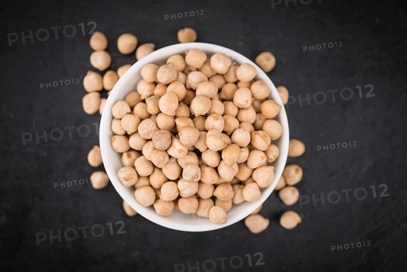 Some dried Chickpeas on a slate slab as detailed close-up shot, selective focus