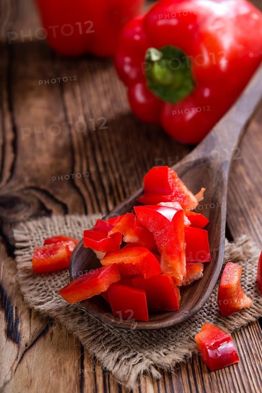 Sliced red Peppers (selective focus) on vintage wooden background