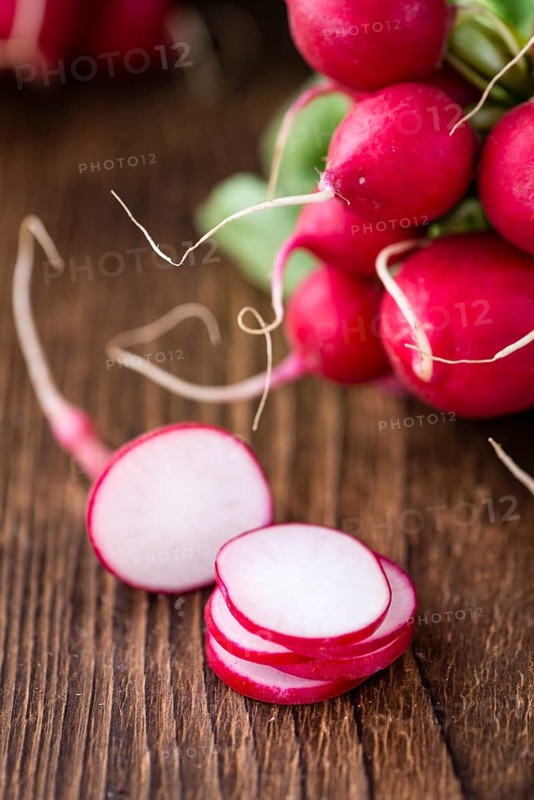 Chopped Radishes (close-up shot) on an old wooden table (selective focus)