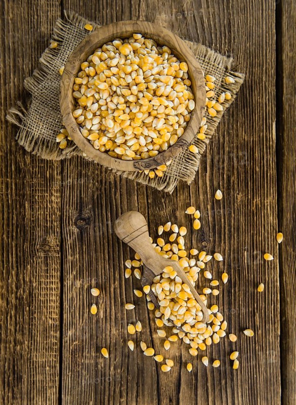 Dried Corn (detailed close-up shot, selective focus) on vintage wooden background