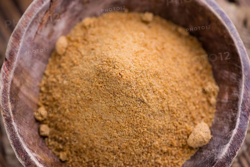 Portion of golden Coconut Sugar (selective focus) on vintage wooden background