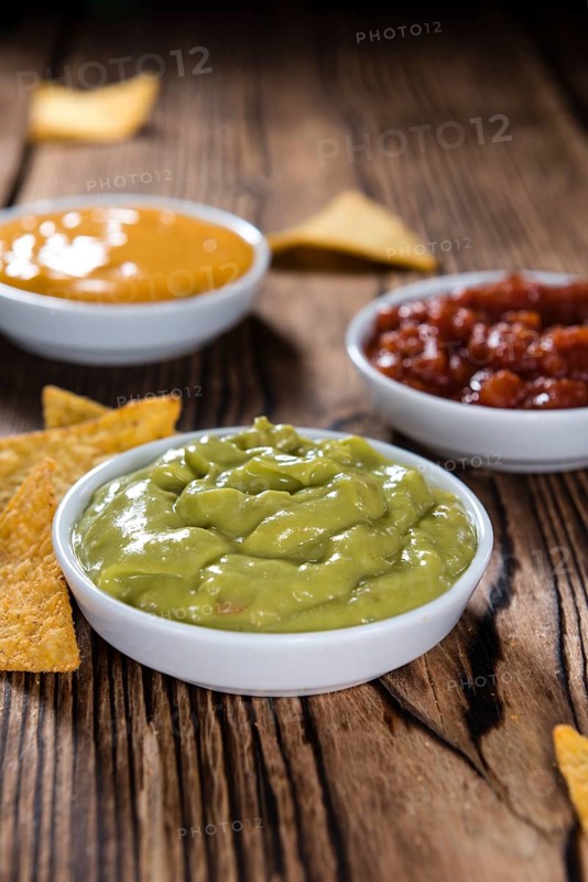 Different sorts of Nacho Dips (soft focus) on wooden background
