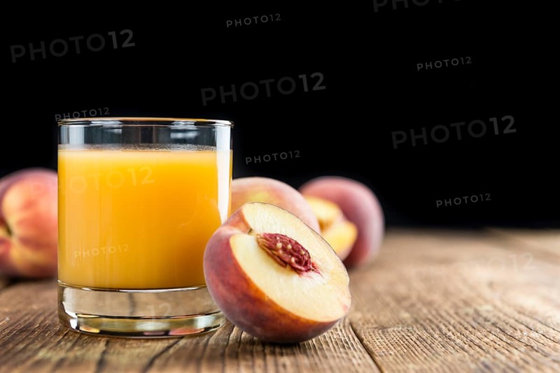 Fresh made Peach juice (detailed close-up shot) on wooden background