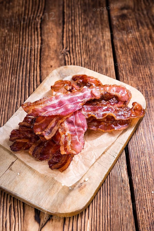Portion of fried Bacon (selective focus) on wooden background