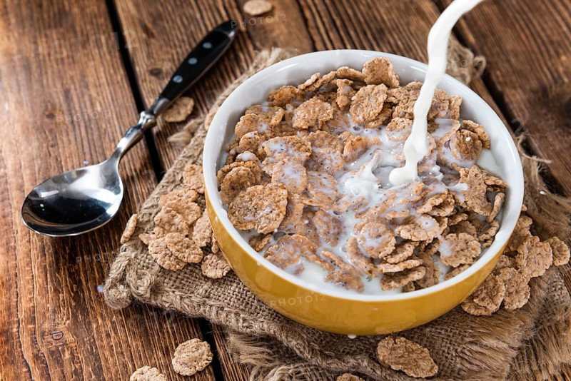 Pouring Milk on a portion of Cornflakes (in a bowl)