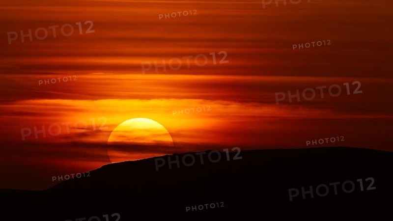 A dramatic sunset behind a hill that bathes the sky in deep red-orange tones, offshore island, Kritinia Castle, St John's Castle, Kritinia, Rhodes, Dodecanese, Greek Islands, Greece, Europe