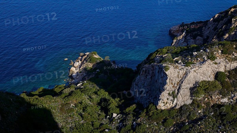 A rocky coast with deep blue sea and dense vegetation on cliffs, Kritinia Castle, St John's Castle, Kritinia, Rhodes, Dodecanese, Greek Islands, Greece, Europe