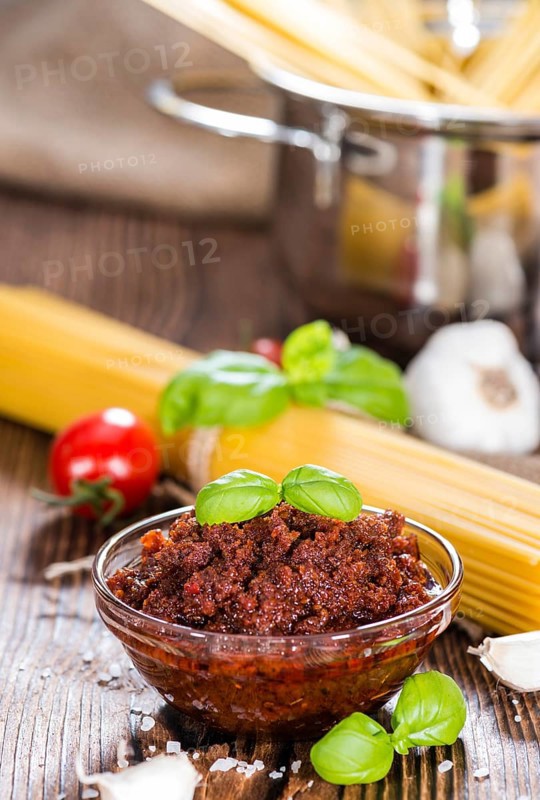 Fresh made Tomato Pesto (close-up shot) on wooden background