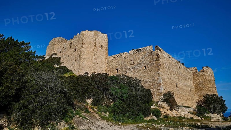 Ruins of a large castle complex, surrounded by dense vegetation and a clear blue sky, Kritinia Castle, St John's Castle, Kritinia, Rhodes, Dodecanese, Greek Islands, Greece, Europe