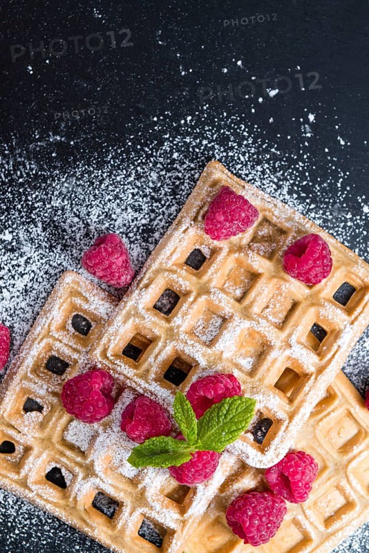 Fresh made Waffles with Raspberries and powder sugar (close-up shot)
