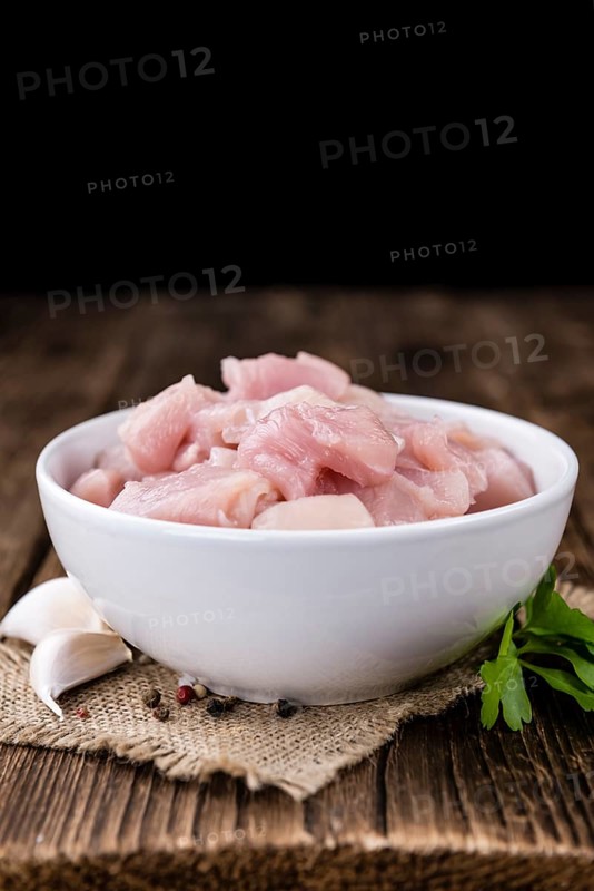 Portion of chopped Chicken Fillet (close-up shot) on wooden background
