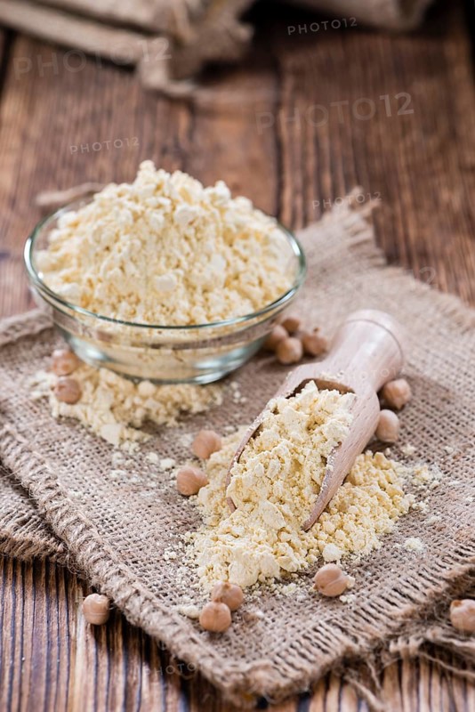 Heap of Chick Pea flour on an old wooden table