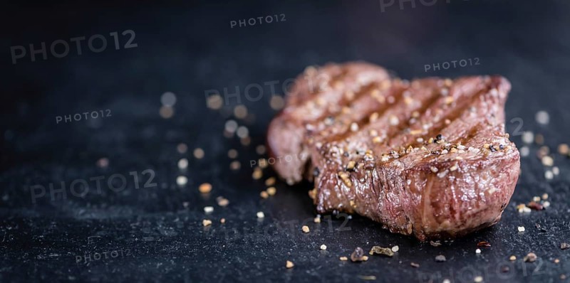 Fresh grilled Beef Steak (selective focus, close-up shot) on dark background