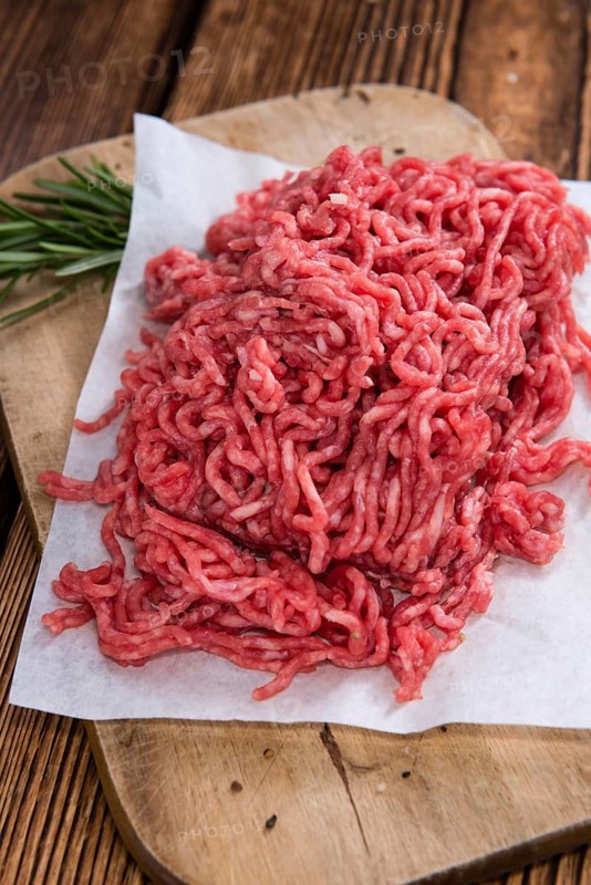 Portion of Minced Meat on an old wooden table (close-up shot)