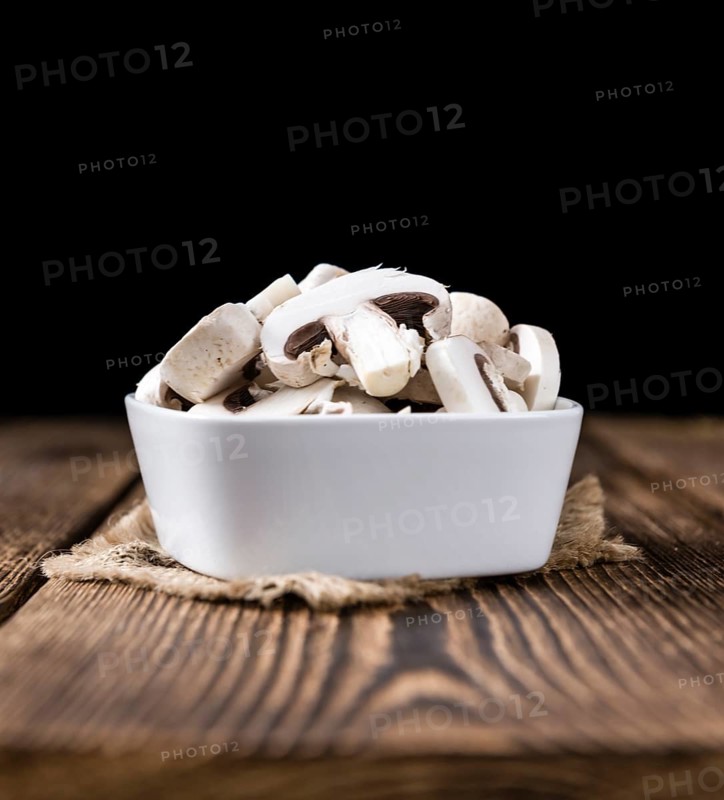 Portion of white Mushrooms (close-up shot) on vintage wooden background