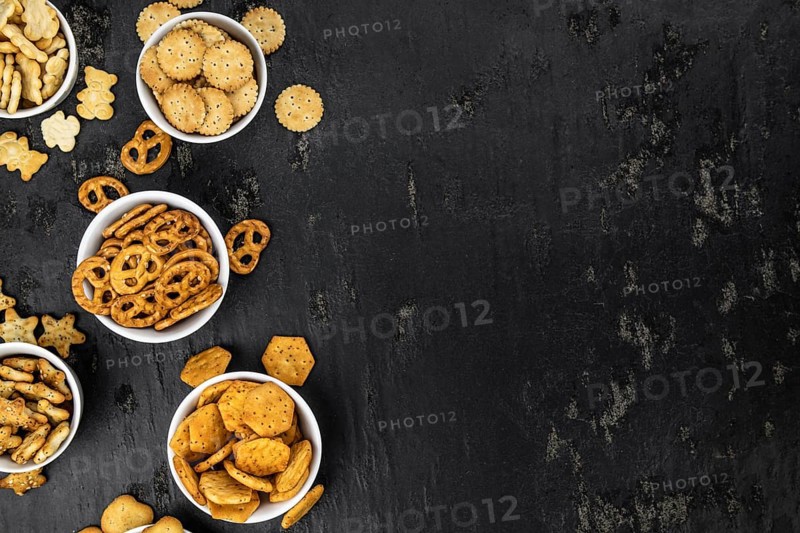 Portion of mixed Snacks on dark background (detailed close up shot, selective focus)