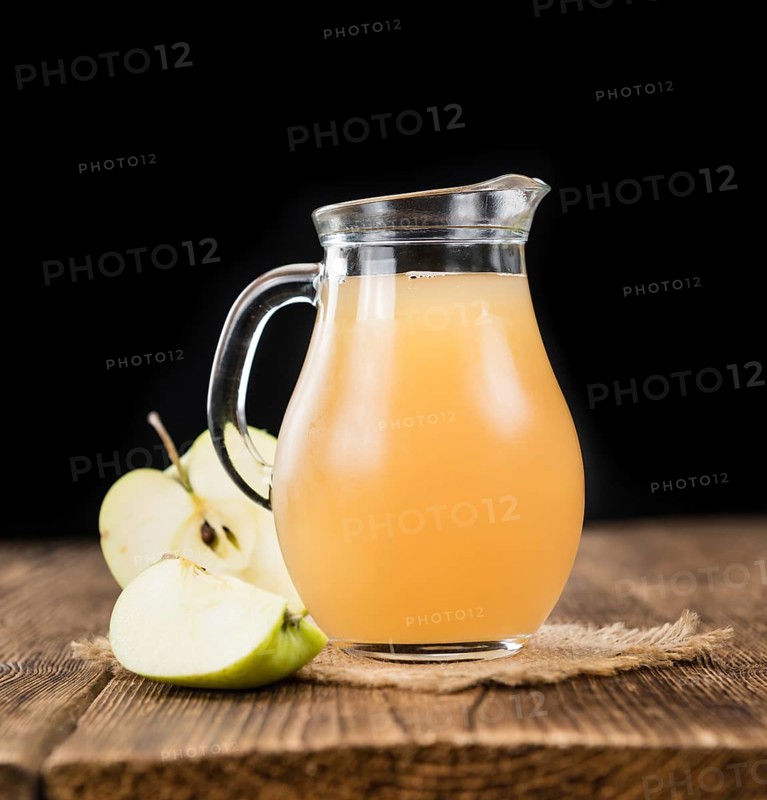 Apple Juice on an old wooden table as detailed close-up shot (selective focus)