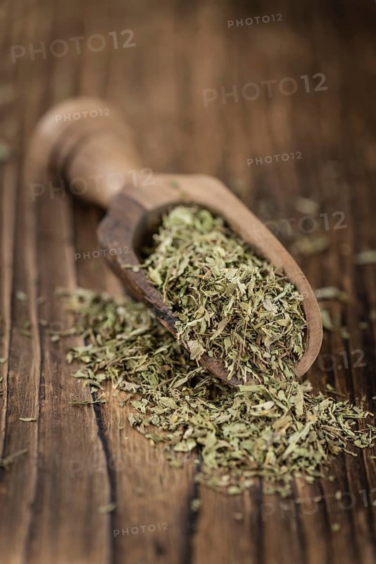 Portion of Stevia Leaves (dried, close-up shot) on wooden background