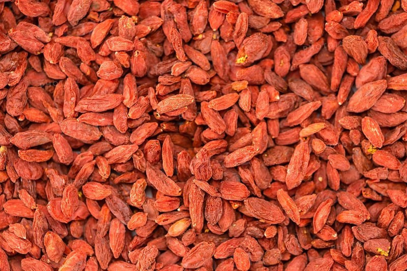 Dried Goji Berries as high detailed close-up shot on a vintage wooden table (selective focus)