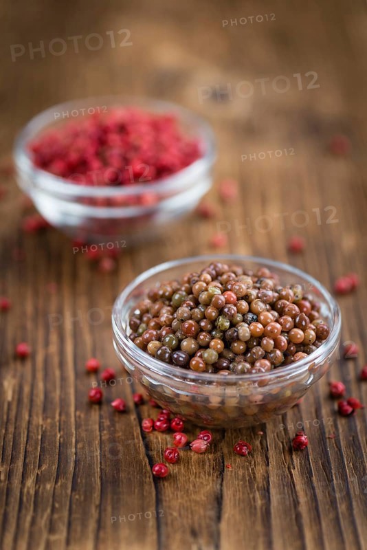 Preserved Pink Peppercorns on a vintage background as detailed close-up shot, selective focus