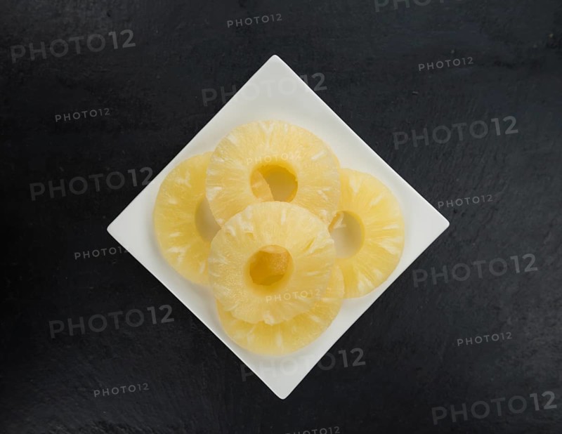 Some fresh Preserved Pineapple Rings on a vintage slate slab, selective focus, close-up shot