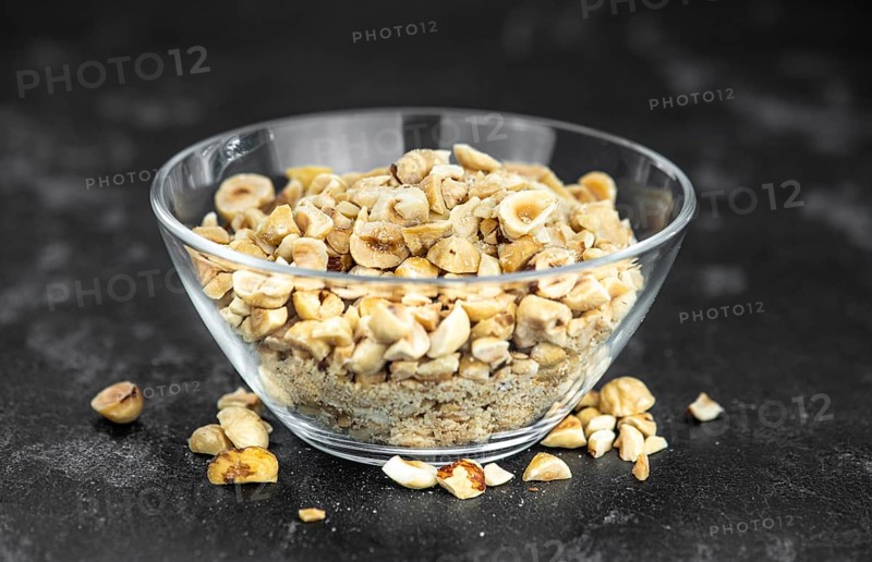 Freshly chopped Hazelnuts as detailed close up shot (selective focus)