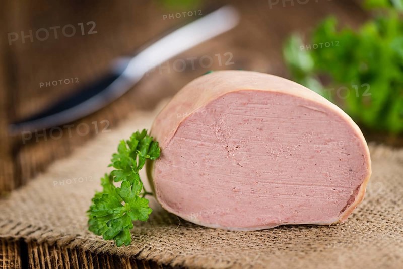 Liverwurst (German cuisine) as high detailed close-up shot on a vintage wooden table (selective focus)