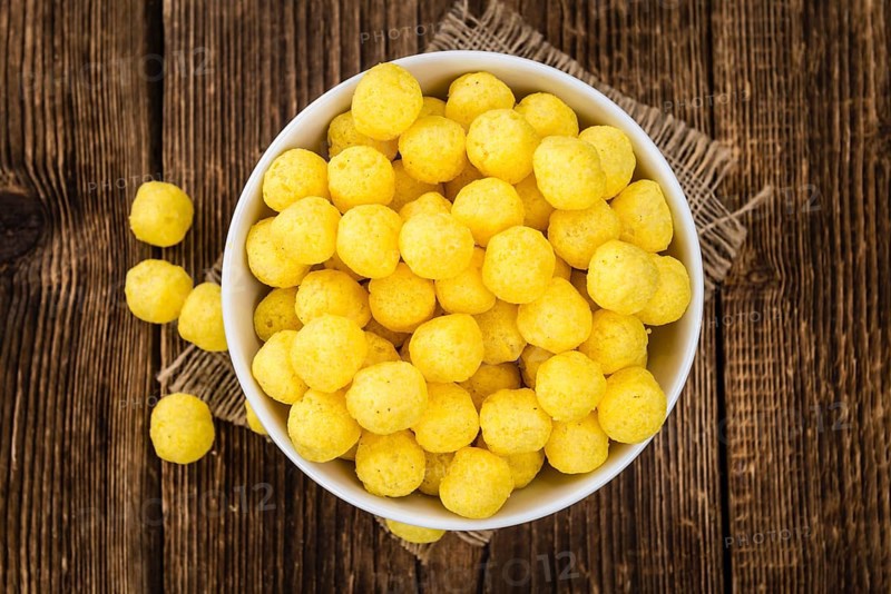 Cheese Balls on rustic wooden background (close-up shot)