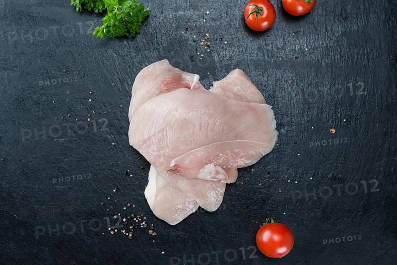Slate slab with raw Chicken Cutlet (close-up shot)