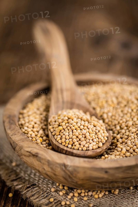 Seeds (Mustard) as high detailed close-up shot on a vintage wooden table (selective focus)