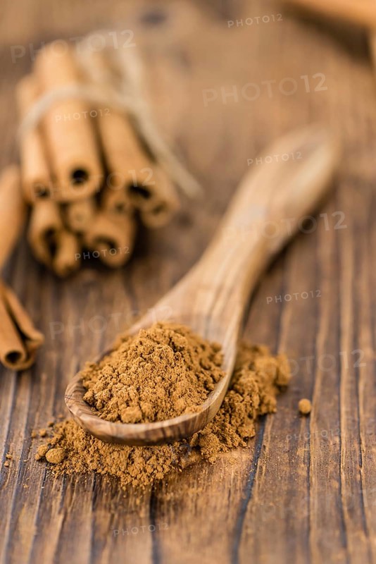 Cinnamon Powder as high detailed close-up shot on a vintage wooden table (selective focus)