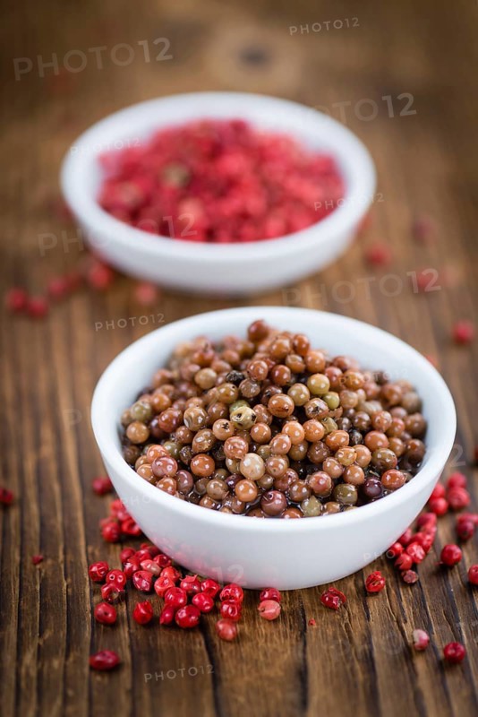 Fresh made Pink Peppercorns (preserved) on an old and rustic wooden table, selective focus, close-up shot