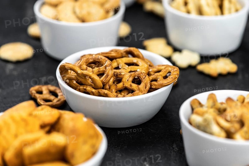 Portion of mixed Snacks on dark background (detailed close up shot, selective focus)