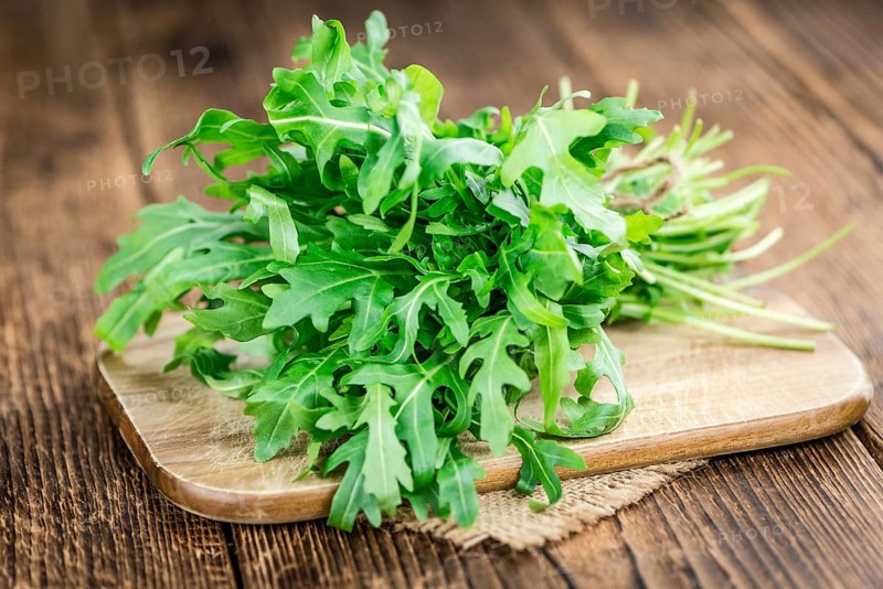 Fresh Arugula (selective focus) as detailed close-up shot on vintage background