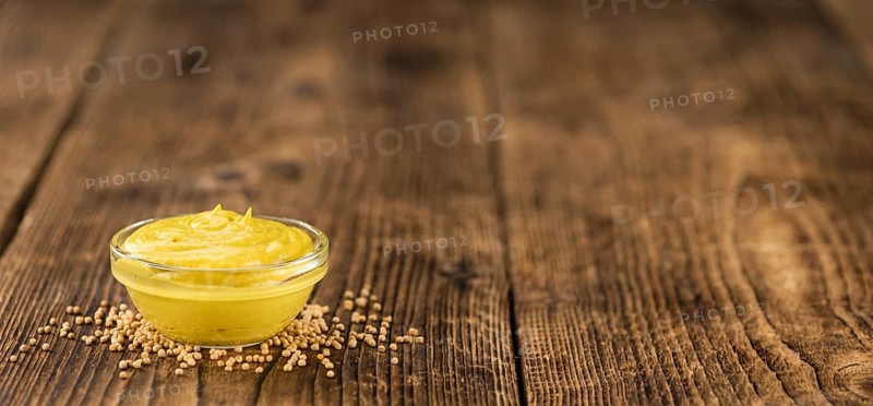 Portion of homemade Mustard on wooden background (selective focus, close-up shot)