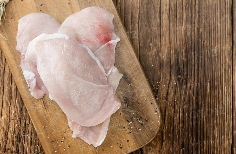 Old wooden table with raw Chicken Cutlet (detailed close-up shot)