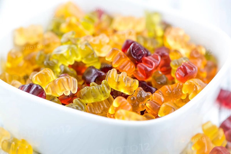 Wooden table with Gummy Bears (close-up shot, selective focus)