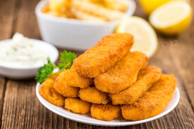 Fisch Sticks (close-up shot) on an old wooden table (selective focus)
