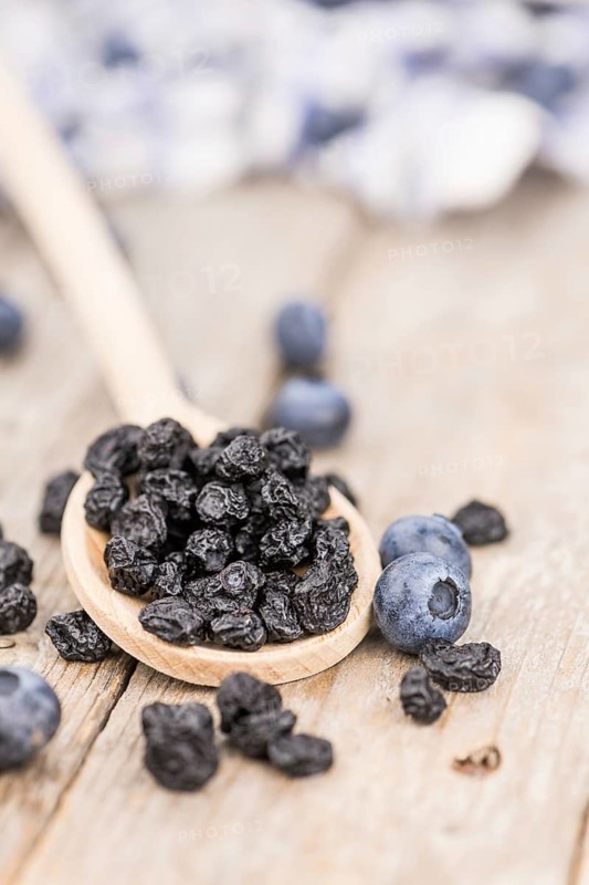 Dried Blueberries as high detailed close-up shot on a vintage wooden table, selective focus