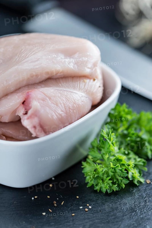 Raw Chicken Cutlet on a slate slab (detailed close-up shot)