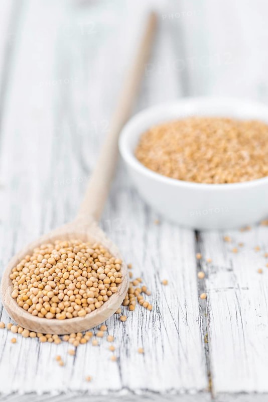 Portion of fresh made Mustard Seeds (close-up shot, selective focus)